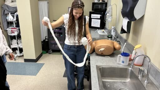 Student bandaging medical dummy