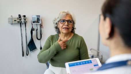 Latin American senior woman explaining her symptoms to a doctor in the consultation room