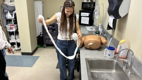 Student bandaging medical dummy