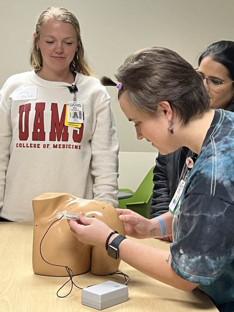 Student practicing shoulder injection on model