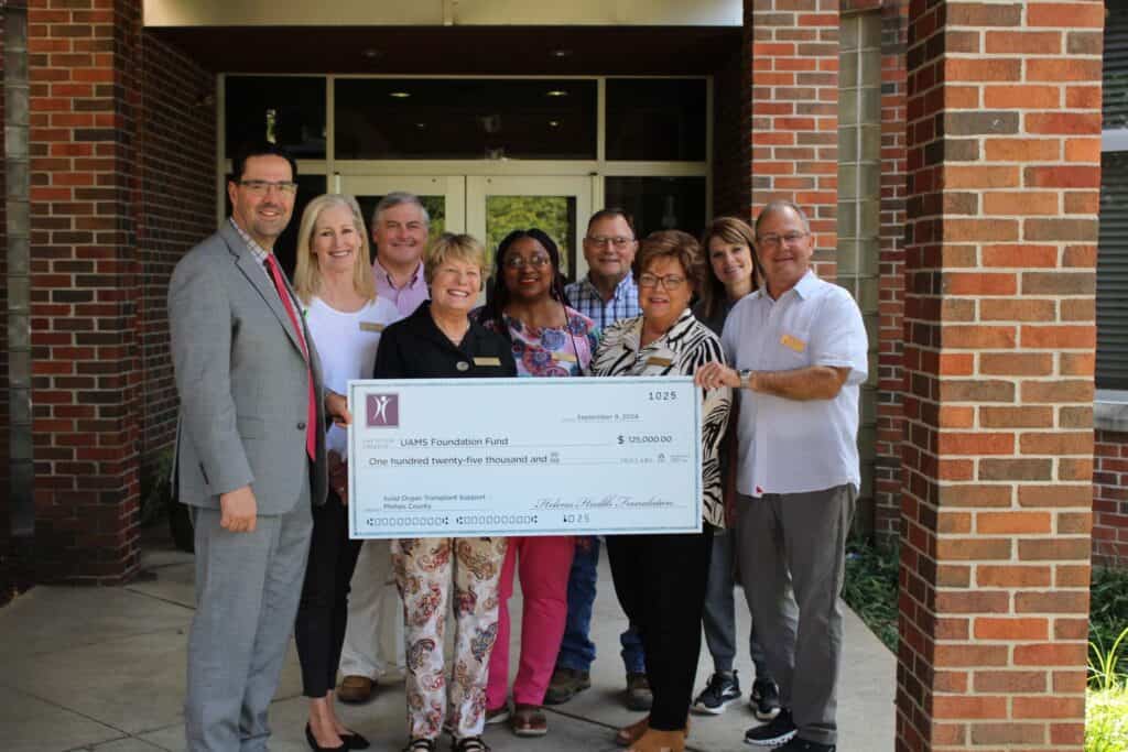 Lyle Burdine, M.D., Ph.D., (left) receives a check from the members of the Helena Health Foundation Board.