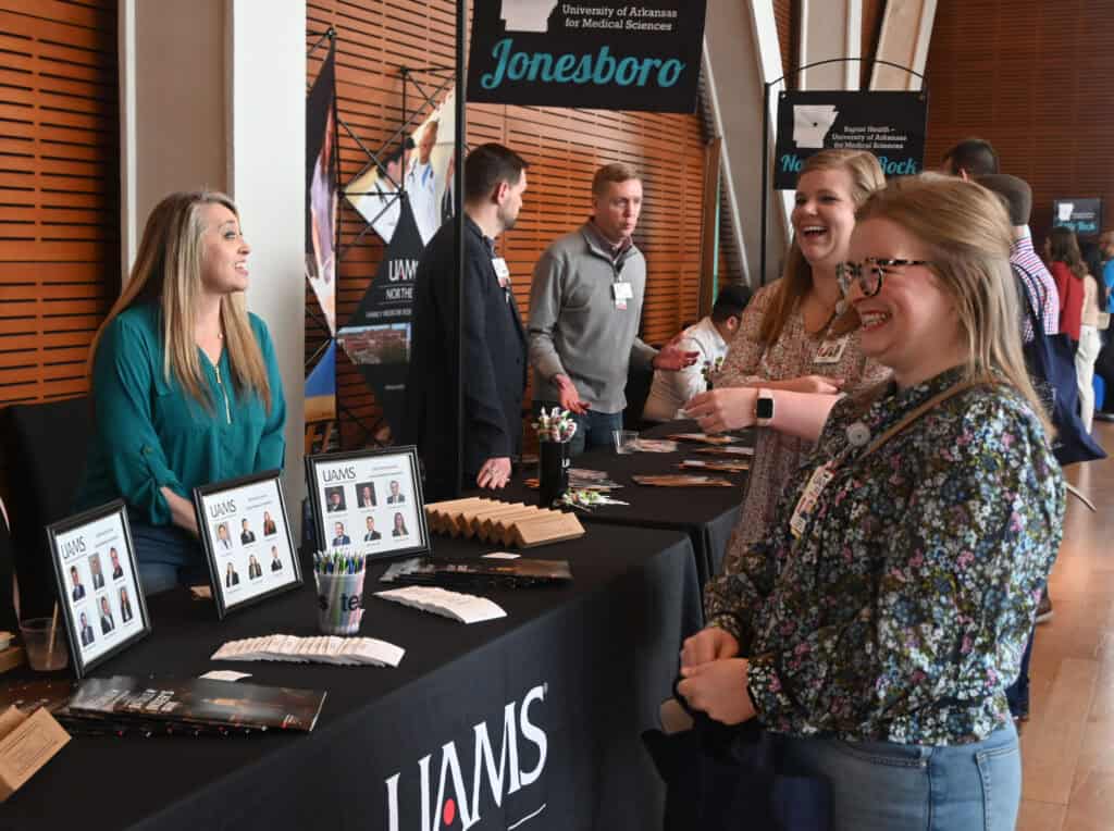 Medical Students visiting booths at a residency recruitment event.