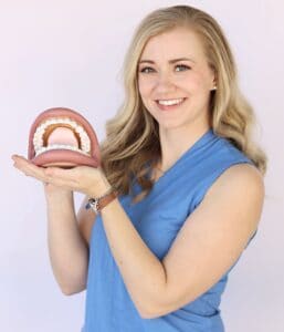 Woman holding a model of a human mouth