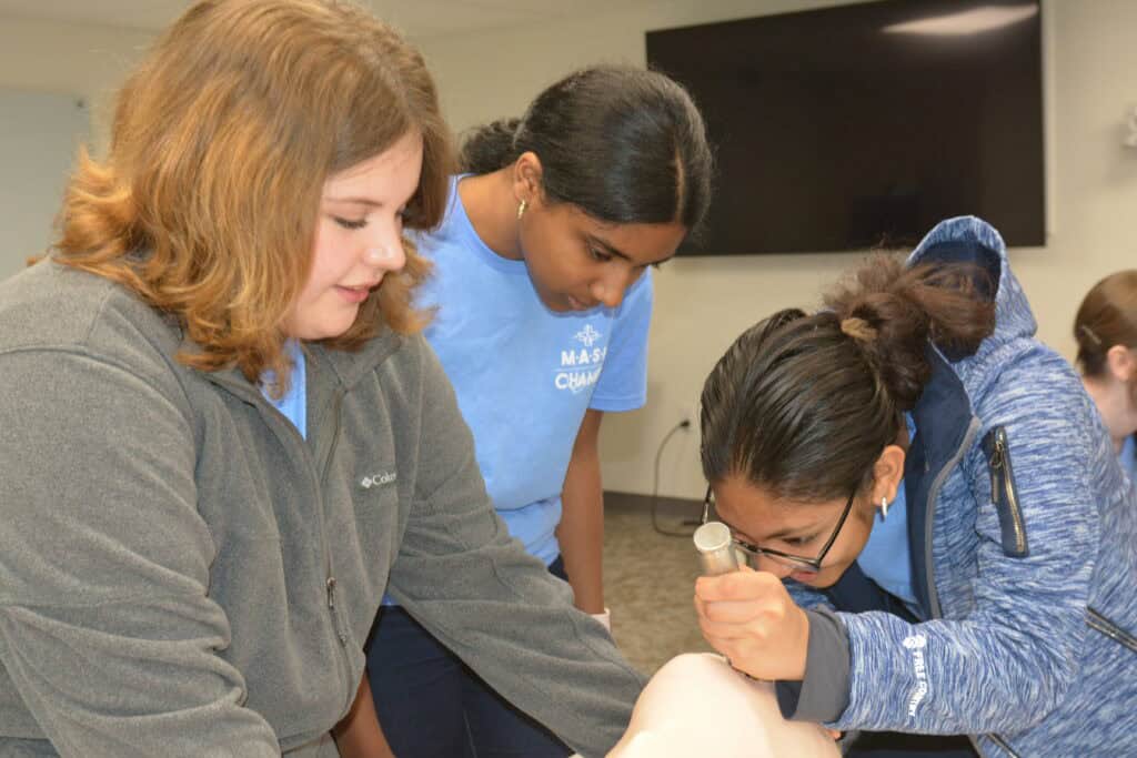 Northwest MASH students examining medical mannequin 