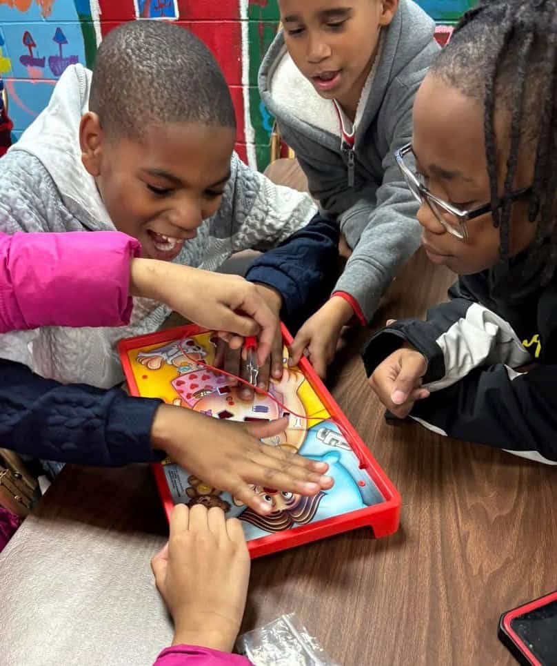 Pine Bluff Club scrub middle school students playing with a surgery game