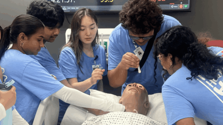 MASH students examining a medical mannequin
